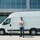 Jeune entrepreneur avec van blanc devant un bureau moderne